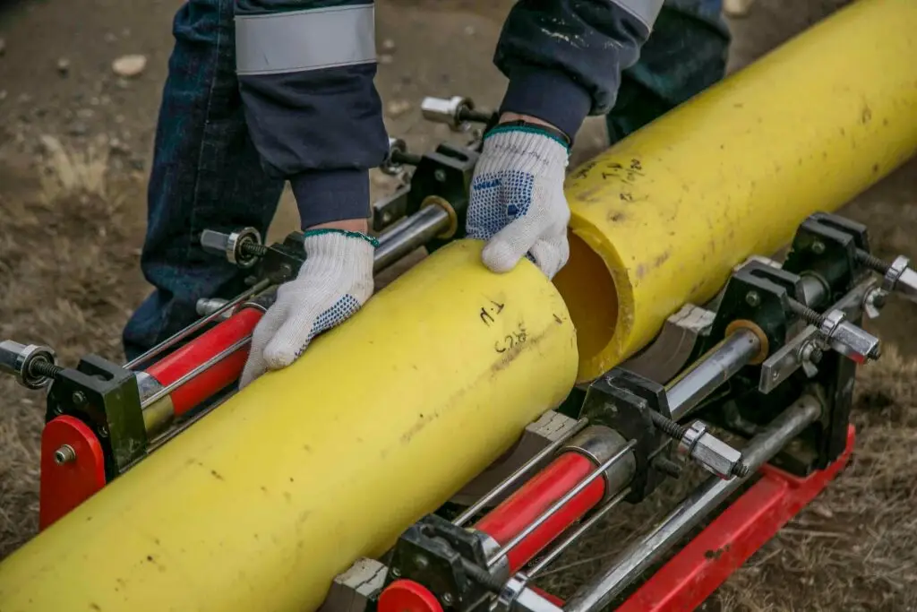 Worker cutting yellow pvc pipe