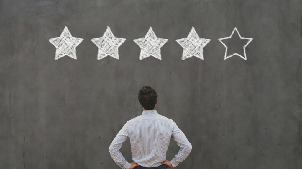 man looking at wall with 4 out of 5 stars on it